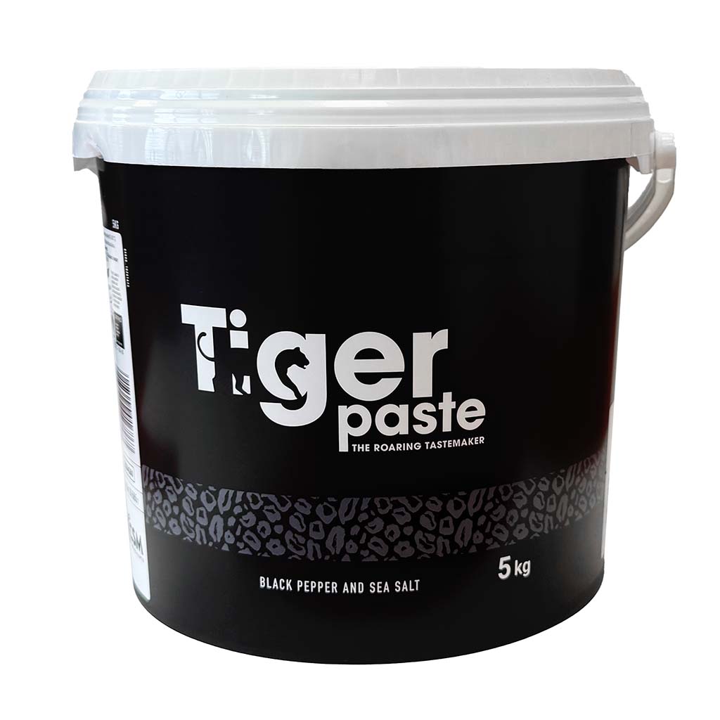 Ein schwarzer Plastikeimer mit weißem Deckel, auf dem 'Tiger Paste – The Roaring Tastemaker' steht. Darunter ist 'Black Pepper and Sea Salt' sowie '5 kg' angegeben.